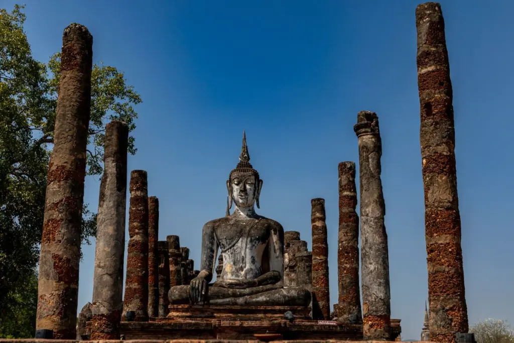 พระพุทธรูปท่ามกลางเสาศิลาแลง โบราณสถานในอุทยานประวัติศาสตร์สุโขทัย
